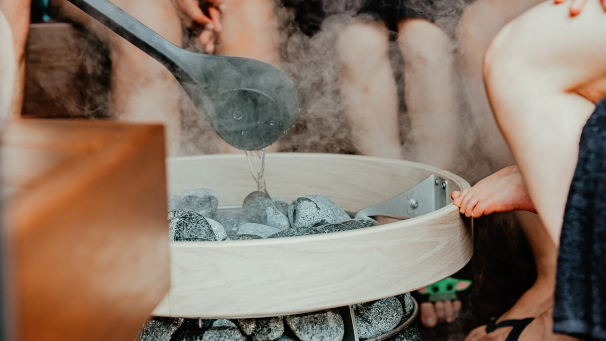 Person adding water for a sauna session